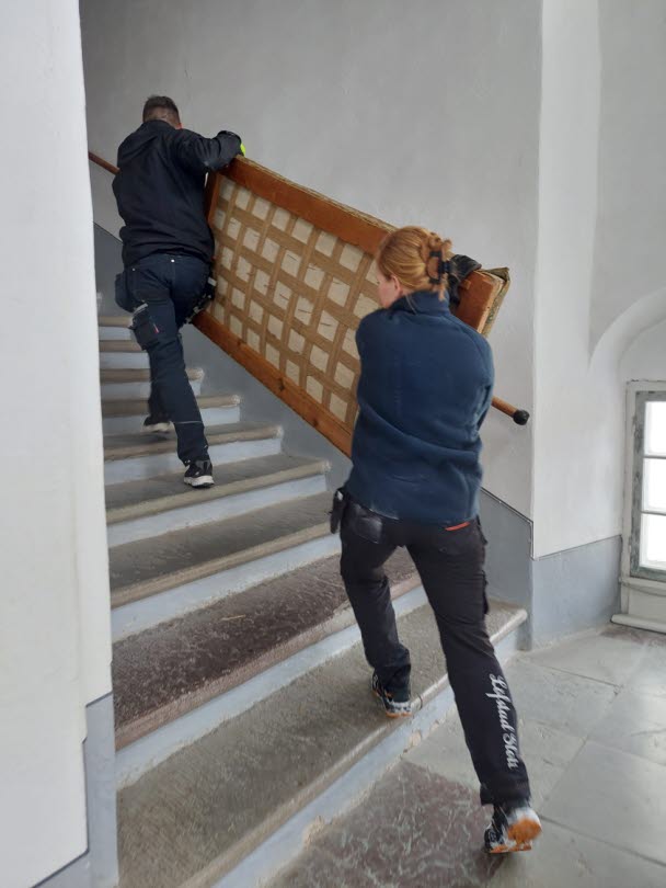 Möbler bärs upp i trapphallen, från köksvåningen till vinden.